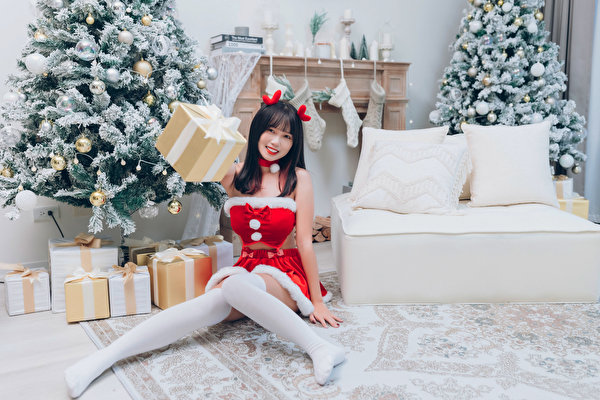 Wallpapers Asian New year Sitting Christmas tree Box Present Frock Stockings Smile young woman