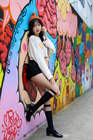 Fotos Asiatisches Graffiti Posiert Wand Bein Long Socken Shorts Sweatshirt Mütze Mädchens