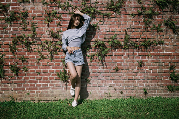 Fotos Asiatische Pose Bein Shorts Bluse Mauer Aus Ziegel Mädchens